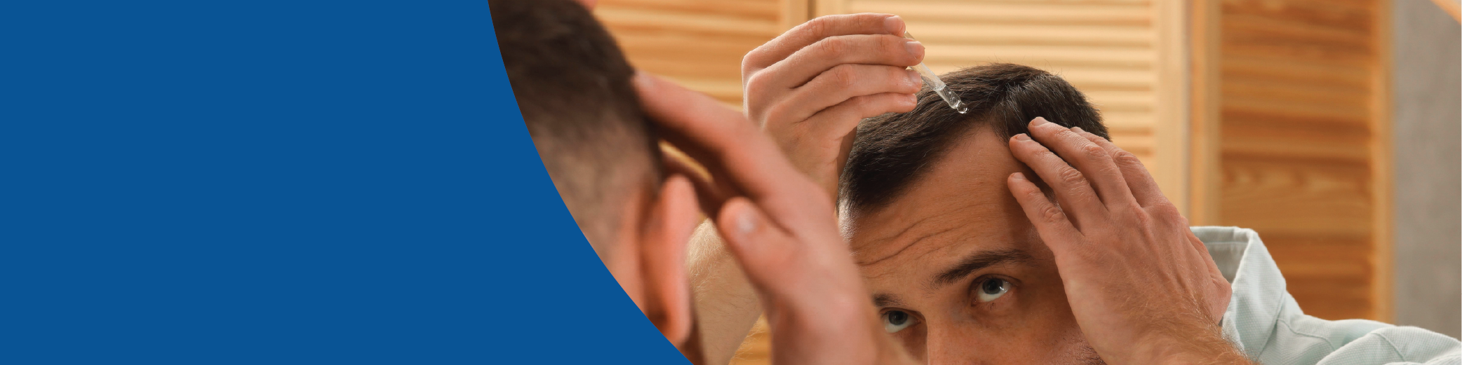 Man treating hair loss with topical treatment in front of mirror.